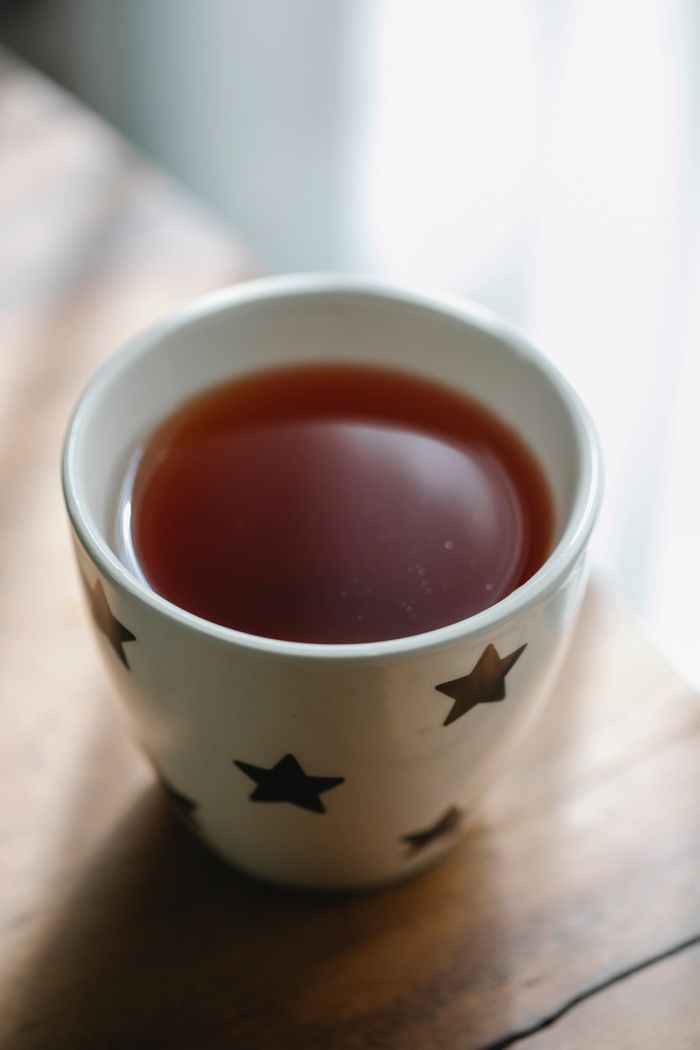 The Art of Drawing Readers In: Your attractive post title goes here Closeup of white ceramic cup with stars of hot aromatic tea placed on wooden table